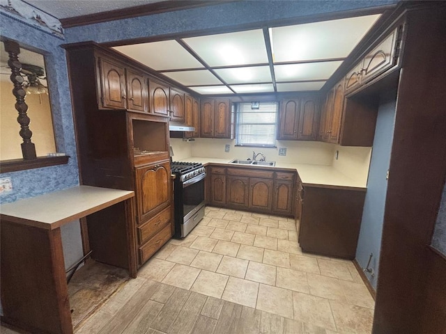 5517 S Karen St, Oklahoma City, OK 73135 - kitchen featuring stainless steel gas stove, wallpapered walls, under cabinet range hood, and light countertops