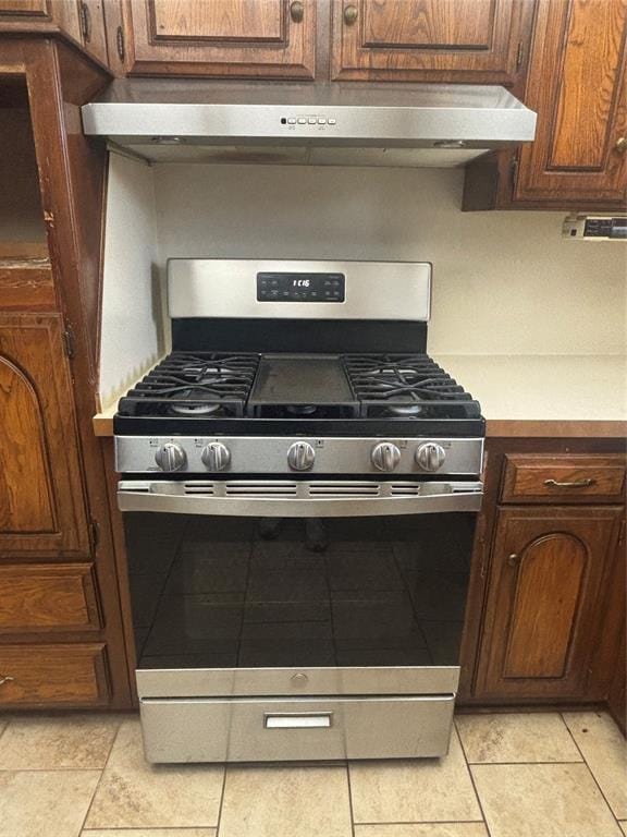 5517 S Karen St, Oklahoma City, OK 73135 - kitchen with gas range, range hood, light countertops, and light tile patterned flooring