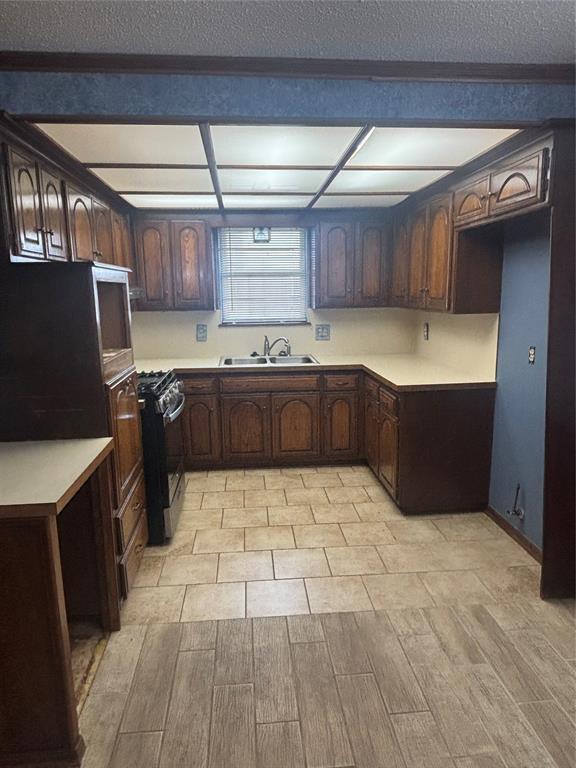 5517 S Karen St, Oklahoma City, OK 73135 - kitchen with stainless steel range oven, wood finish floors, light countertops, and dark brown cabinets