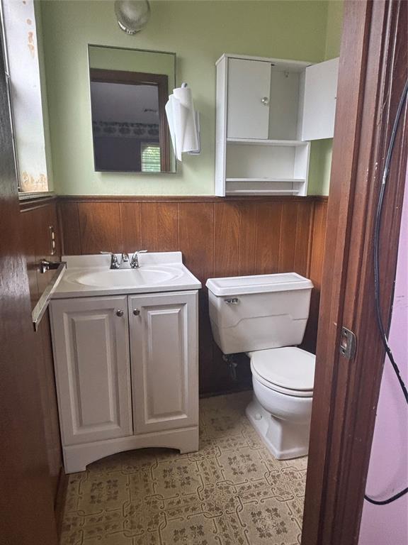 5517 S Karen St, Oklahoma City, OK 73135 - bathroom with vanity, wainscoting, wood walls, and tile patterned floors