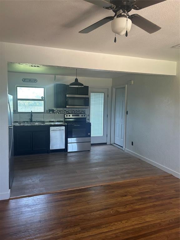 5326 NW Columbia Ave, Lawton, OK 73505 - kitchen with appliances with stainless steel finishes, dark wood finished floors, dark countertops, a ceiling fan, and a textured ceiling