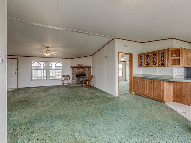 11924 W County Rd 74, Crescent, OK 73028 - unfurnished living room featuring carpet floors, a ceiling fan, a stone fireplace, and crown molding