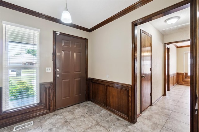 708 Cactus Ct, Yukon, OK 73099 - foyer entrance featuring a wainscoted wall, crown molding, wooden walls, and light tile patterned floors