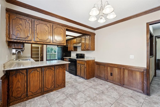 708 Cactus Ct, Yukon, OK 73099 - kitchen with black appliances, under cabinet range hood, a chandelier, a peninsula, and a wainscoted wall