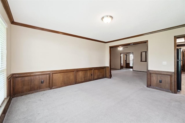 708 Cactus Ct, Yukon, OK 73099 - unfurnished room with light carpet, a wainscoted wall, ornamental molding, and a ceiling fan