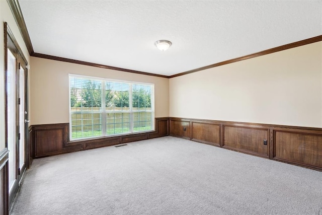 708 Cactus Ct, Yukon, OK 73099 - empty room with wainscoting, light carpet, ornamental molding, and a textured ceiling