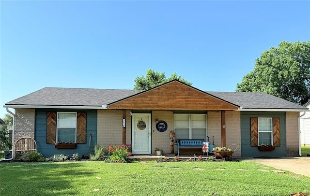 1616 NE 5th St, Moore, OK 73160 - view of front of property featuring brick siding, a front yard, roof with shingles, and a porch