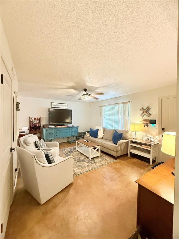 1616 NE 5th St, Moore, OK 73160 - living room with a ceiling fan, a textured ceiling, and finished concrete flooring