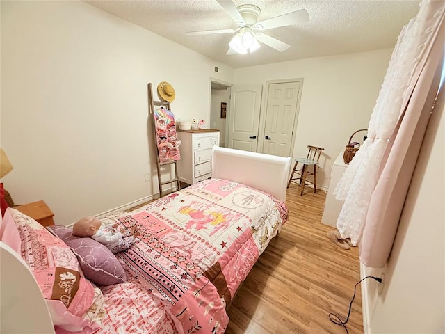 1616 NE 5th St, Moore, OK 73160 - bedroom with light wood-type flooring, a textured ceiling, and a ceiling fan