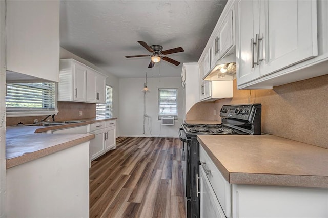 406 SW 4th St, Tuttle, OK 73089 - kitchen featuring black electric range, under cabinet range hood, a ceiling fan, and white cabinets