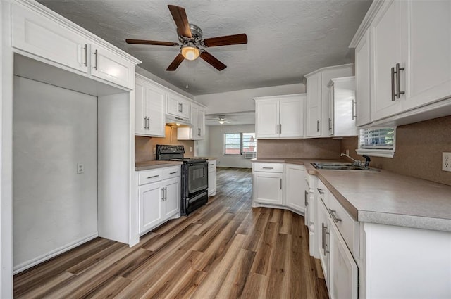 406 SW 4th St, Tuttle, OK 73089 - kitchen featuring black range with electric cooktop, ceiling fan, wood finished floors, white cabinets, and under cabinet range hood