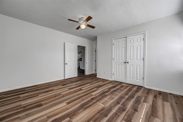 406 SW 4th St, Tuttle, OK 73089 - unfurnished bedroom featuring wood finished floors, a closet, a ceiling fan, and a textured ceiling