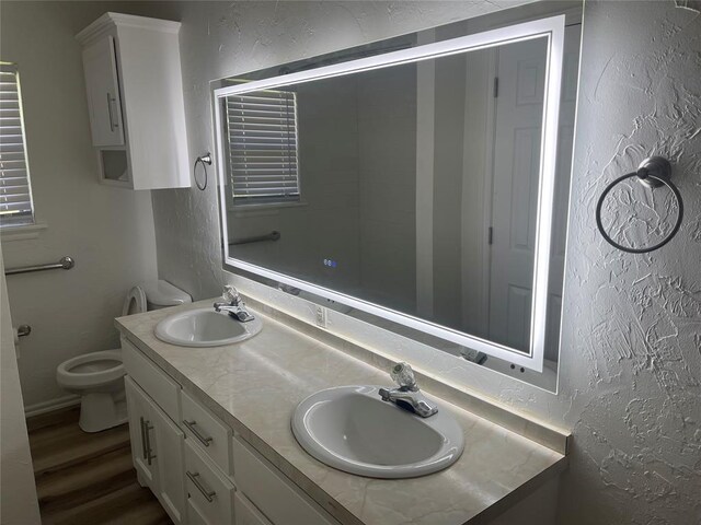 406 SW 4th St, Tuttle, OK 73089 - bathroom with a textured wall, double vanity, wood finished floors, and a shower