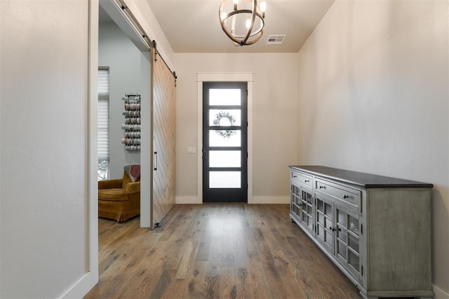 5017 Yale Bridge Ct, Edmond, OK 73034 - entrance foyer with a barn door, dark wood-style flooring, and a chandelier