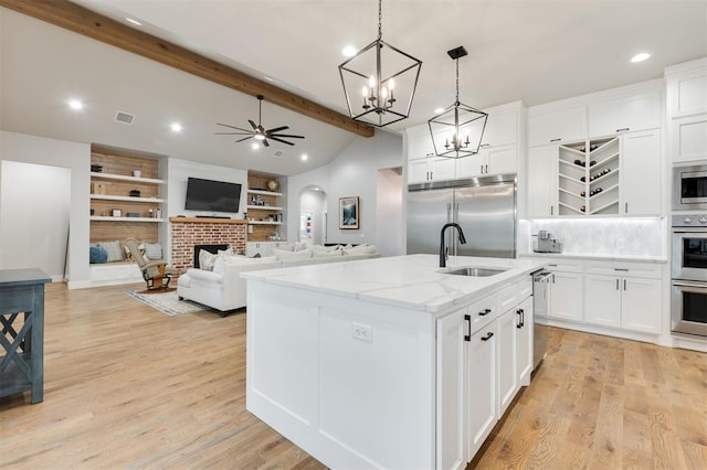 5017 Yale Bridge Ct, Edmond, OK 73034 - kitchen featuring built in appliances, ceiling fan, a brick fireplace, white cabinetry, and recessed lighting