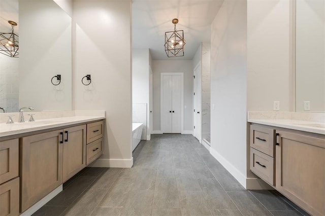 5017 Yale Bridge Ct, Edmond, OK 73034 - bathroom featuring two vanities, a garden tub, a shower stall, and a chandelier