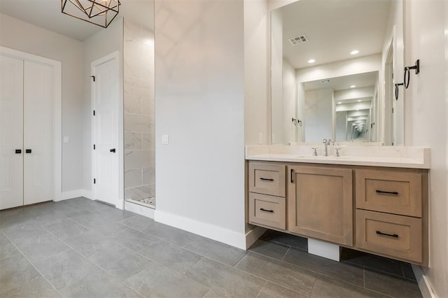 5017 Yale Bridge Ct, Edmond, OK 73034 - bathroom featuring vanity, tiled shower, and tile patterned flooring