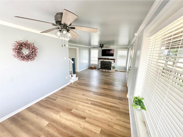 15274 US Highway 283, Blair, OK 73526 - unfurnished living room featuring crown molding, light wood-style floors, a fireplace, a ceiling fan, and stairs