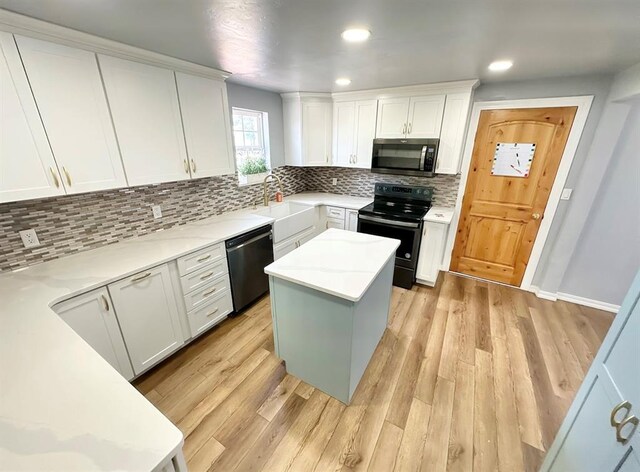 15274 US Highway 283, Blair, OK 73526 - kitchen featuring black electric range, dishwasher, stainless steel microwave, white cabinetry, and backsplash