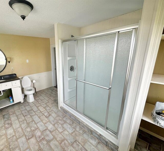 15274 US Highway 283, Blair, OK 73526 - bathroom featuring a shower stall, a wainscoted wall, vanity, and a textured ceiling