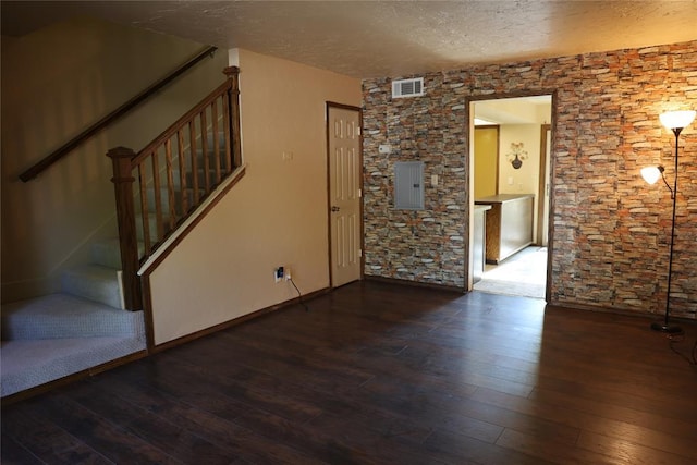 3823 N Harvard Ave Unit 12, Oklahoma City, OK 73122 - unfurnished living room featuring hardwood / wood-style floors, a textured ceiling, stairs, and electric panel