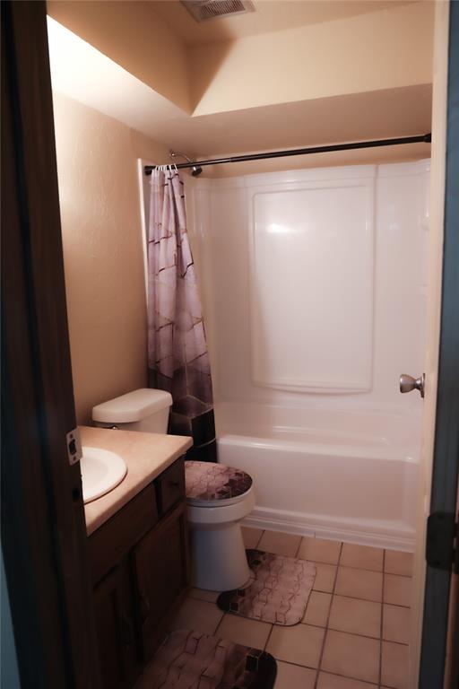 3823 N Harvard Ave Unit 12, Oklahoma City, OK 73122 - bathroom featuring shower / bath combination with curtain, vanity, and tile patterned flooring