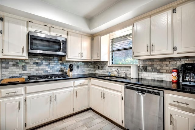 1713 Shadow Ct, Edmond, OK 73013 - kitchen featuring stainless steel appliances, dark countertops, tasteful backsplash, and white cabinets