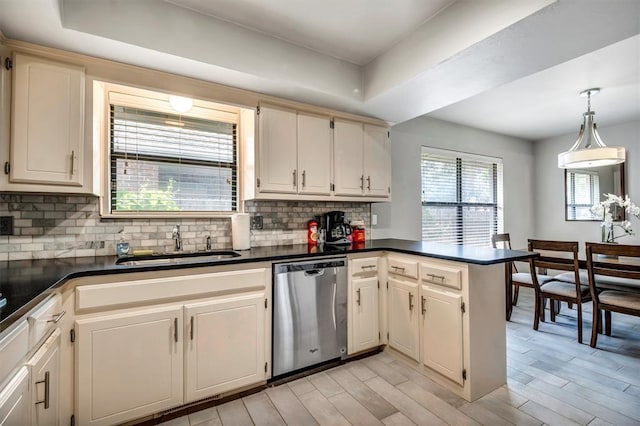 1713 Shadow Ct, Edmond, OK 73013 - kitchen featuring stainless steel dishwasher, dark countertops, a peninsula, and tasteful backsplash