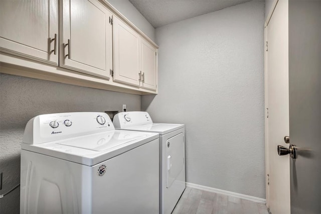 1713 Shadow Ct, Edmond, OK 73013 - laundry area featuring washer and clothes dryer, cabinet space, light wood finished floors, and a textured wall