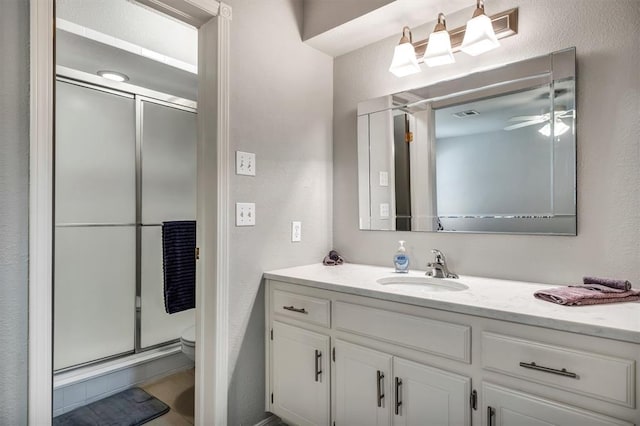 1713 Shadow Ct, Edmond, OK 73013 - full bath featuring vanity, ceiling fan, a shower with shower door, and a textured wall