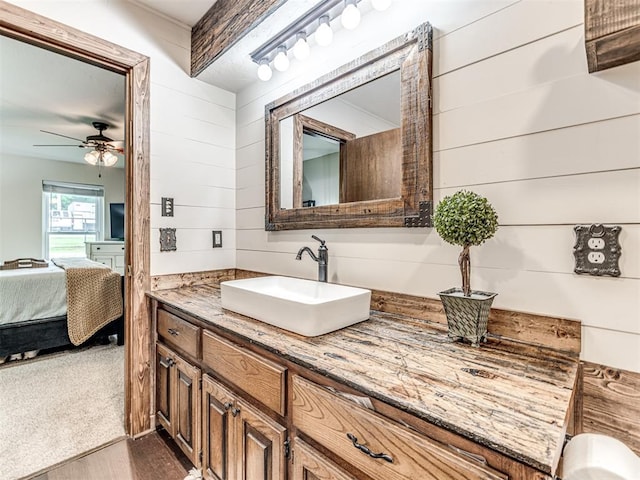 8001 84th St, Noble, OK 73068 - ensuite bathroom with vanity, wood finished floors, ceiling fan, and wooden walls