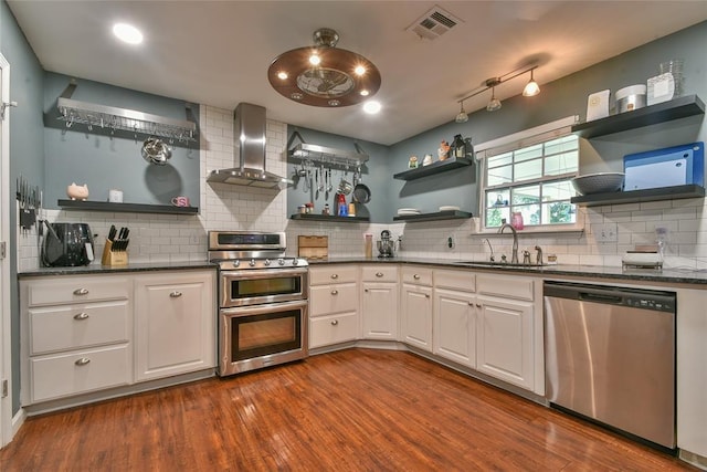 1107 W Windsor Way, Mustang, OK 73064 - kitchen with stainless steel appliances, open shelves, wall chimney range hood, decorative backsplash, and white cabinets
