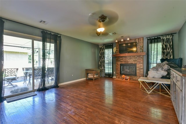 1107 W Windsor Way, Mustang, OK 73064 - unfurnished living room with ceiling fan, a brick fireplace, and wood finished floors