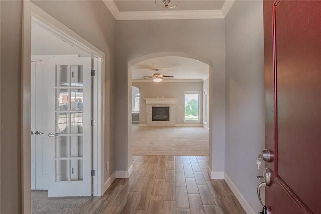 12037 Ashford Dr, Yukon, OK 73099 - carpeted entrance foyer with arched walkways, crown molding, a ceiling fan, a fireplace, and wood finished floors