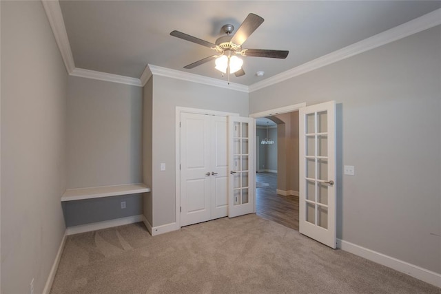 12037 Ashford Dr, Yukon, OK 73099 - unfurnished bedroom featuring french doors, ornamental molding, carpet flooring, arched walkways, and ceiling fan