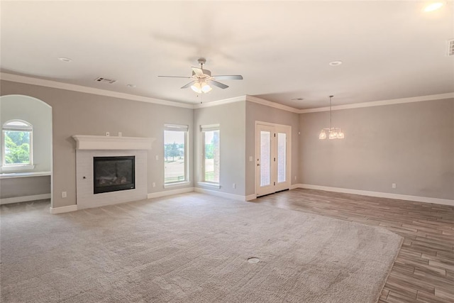 12037 Ashford Dr, Yukon, OK 73099 - unfurnished living room with healthy amount of natural light, a glass covered fireplace, ceiling fan, wood finished floors, and ornamental molding