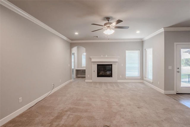 12037 Ashford Dr, Yukon, OK 73099 - unfurnished living room featuring arched walkways, ceiling fan, ornamental molding, light carpet, and recessed lighting