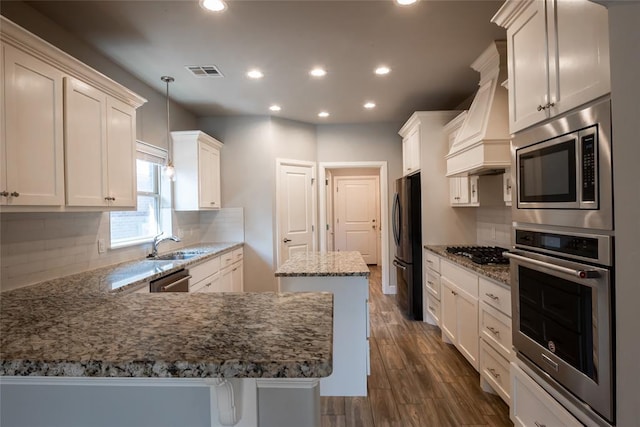12037 Ashford Dr, Yukon, OK 73099 - kitchen featuring stainless steel appliances, recessed lighting, backsplash, stone counters, and a peninsula