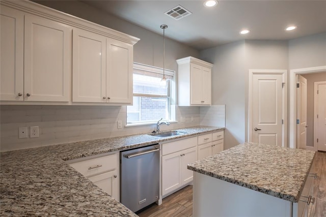 12037 Ashford Dr, Yukon, OK 73099 - kitchen with stainless steel dishwasher, wood finished floors, backsplash, and recessed lighting