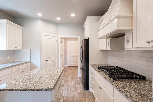 12037 Ashford Dr, Yukon, OK 73099 - kitchen featuring custom exhaust hood, stainless steel gas stovetop, white cabinets, freestanding refrigerator, and recessed lighting