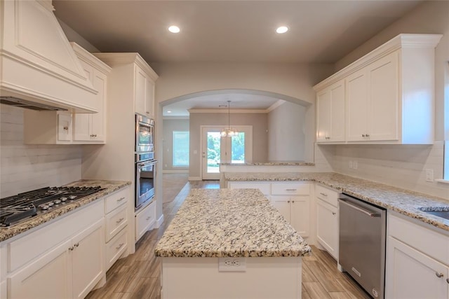 12037 Ashford Dr, Yukon, OK 73099 - kitchen with appliances with stainless steel finishes, custom range hood, arched walkways, crown molding, and recessed lighting