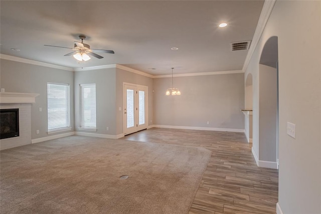 12037 Ashford Dr, Yukon, OK 73099 - unfurnished living room with a fireplace, a chandelier, ceiling fan, wood finished floors, and crown molding