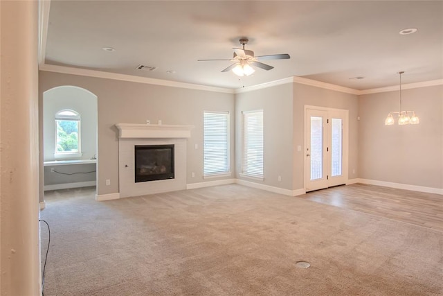 12037 Ashford Dr, Yukon, OK 73099 - unfurnished living room with light colored carpet, a glass covered fireplace, ceiling fan, a chandelier, and arched walkways