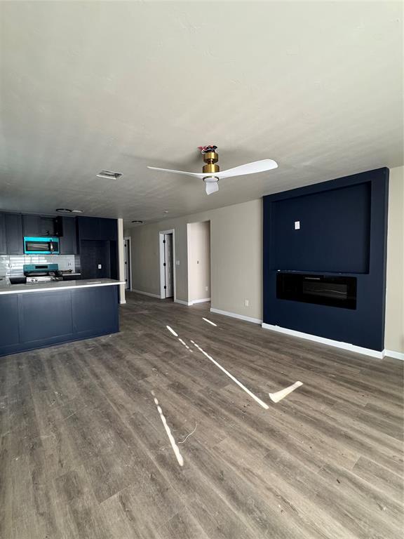 1822 N Jordan Ave, Oklahoma City, OK 73111 - unfurnished living room featuring wood finished floors and ceiling fan