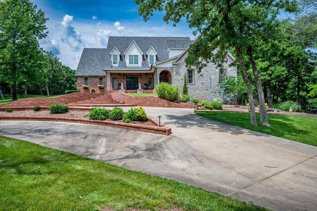 10035 Stone Gate Way, Arcadia, OK 73007 - view of front of property featuring driveway, brick siding, a front lawn, and a porch