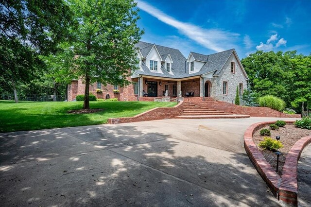 10035 Stone Gate Way, Arcadia, OK 73007 - view of front facade with brick siding, a front yard, and a porch