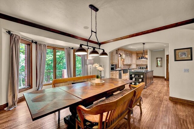 10035 Stone Gate Way, Arcadia, OK 73007 - dining room featuring arched walkways and light wood-style flooring