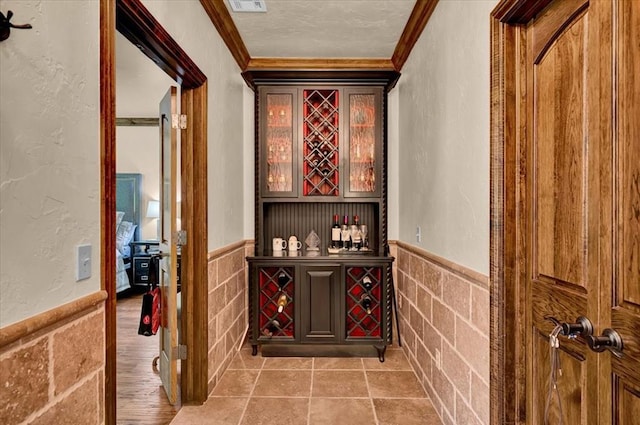 10035 Stone Gate Way, Arcadia, OK 73007 - wine area with ornamental molding, wainscoting, a textured wall, a textured ceiling, and a dry bar