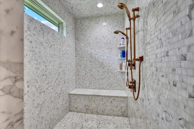 10035 Stone Gate Way, Arcadia, OK 73007 - bathroom featuring tiled shower and tile walls