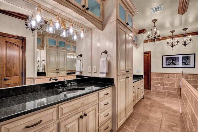 10035 Stone Gate Way, Arcadia, OK 73007 - bathroom featuring a chandelier, vanity, ornamental molding, and a wainscoted wall